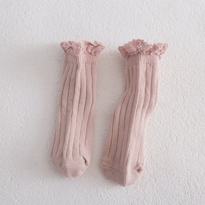 Girls' lace frilly ankle socks in a folded stack, gentle cotton material, various pastel colors