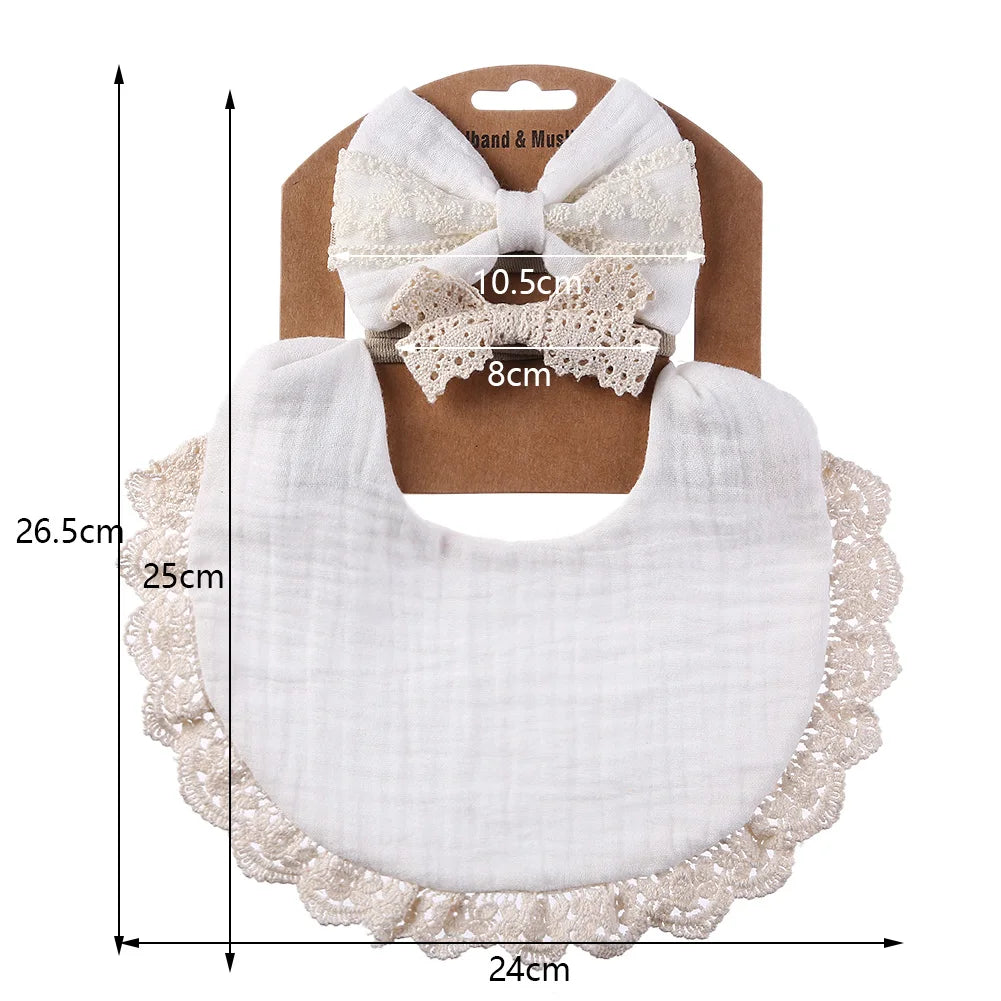 Close-up of a white muslin cotton baby bib, excellent for newborn feeding and dribble, with elegant lace detail.