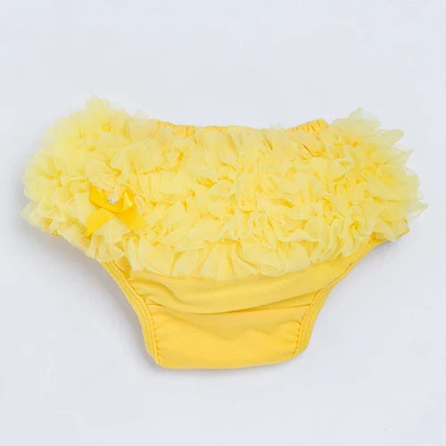 Close-up of ruffled detail on a white cotton blend diaper cover for infants, soft baby bottoms
