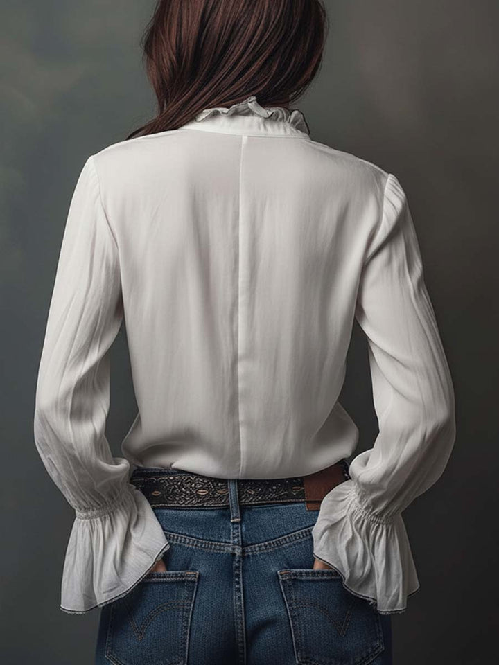 Stylish white long-sleeve blouse with a unique zip-front design & fashionable bell cuffs. Versatile women's top.