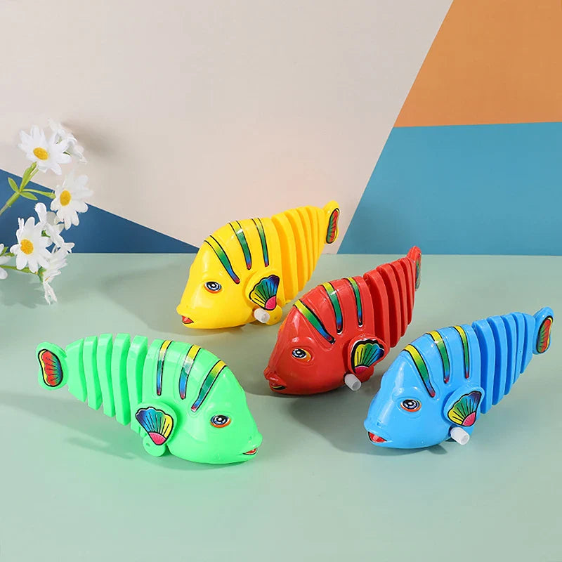 Close-up of a smiling child playing with a wiggling wind-up fish toy