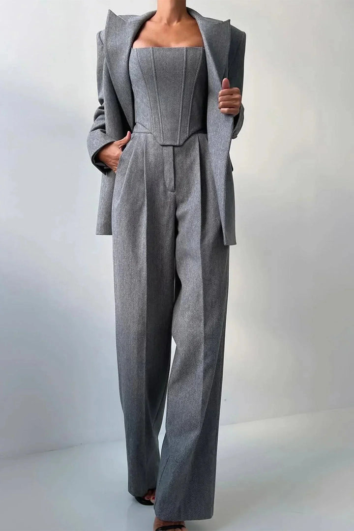 Model wearing a women's 3-piece set: corset bustier, wide leg pants & oversized blazer for a confident look.