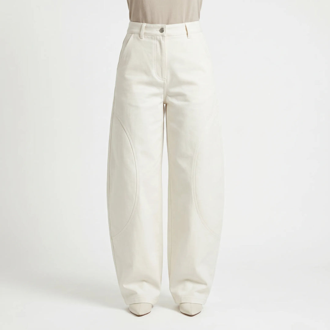 Model wearing women's baggy barrel-leg low-rise jeans. Relaxed fit pants, great for a casual summer look.