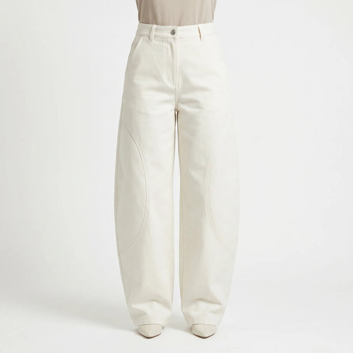 Model wearing women's baggy barrel-leg low-rise jeans. Relaxed fit pants, great for a casual summer look.