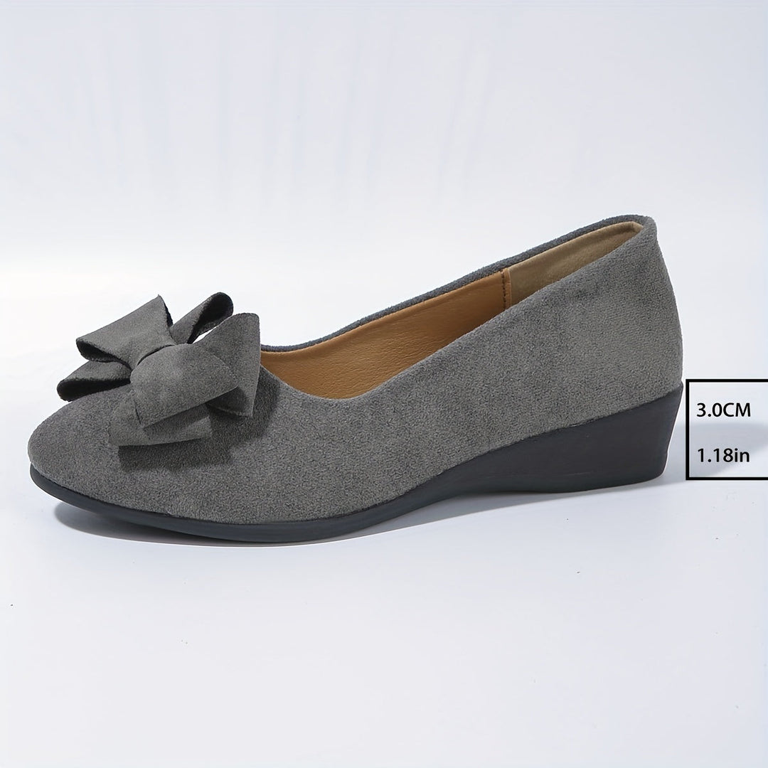 Modern women's slip-on wedge flats, round toe, bow detail for elegant style.