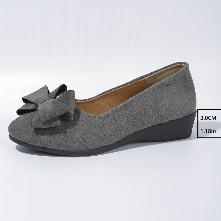 Modern women's slip-on wedge flats, round toe, bow detail for elegant style.