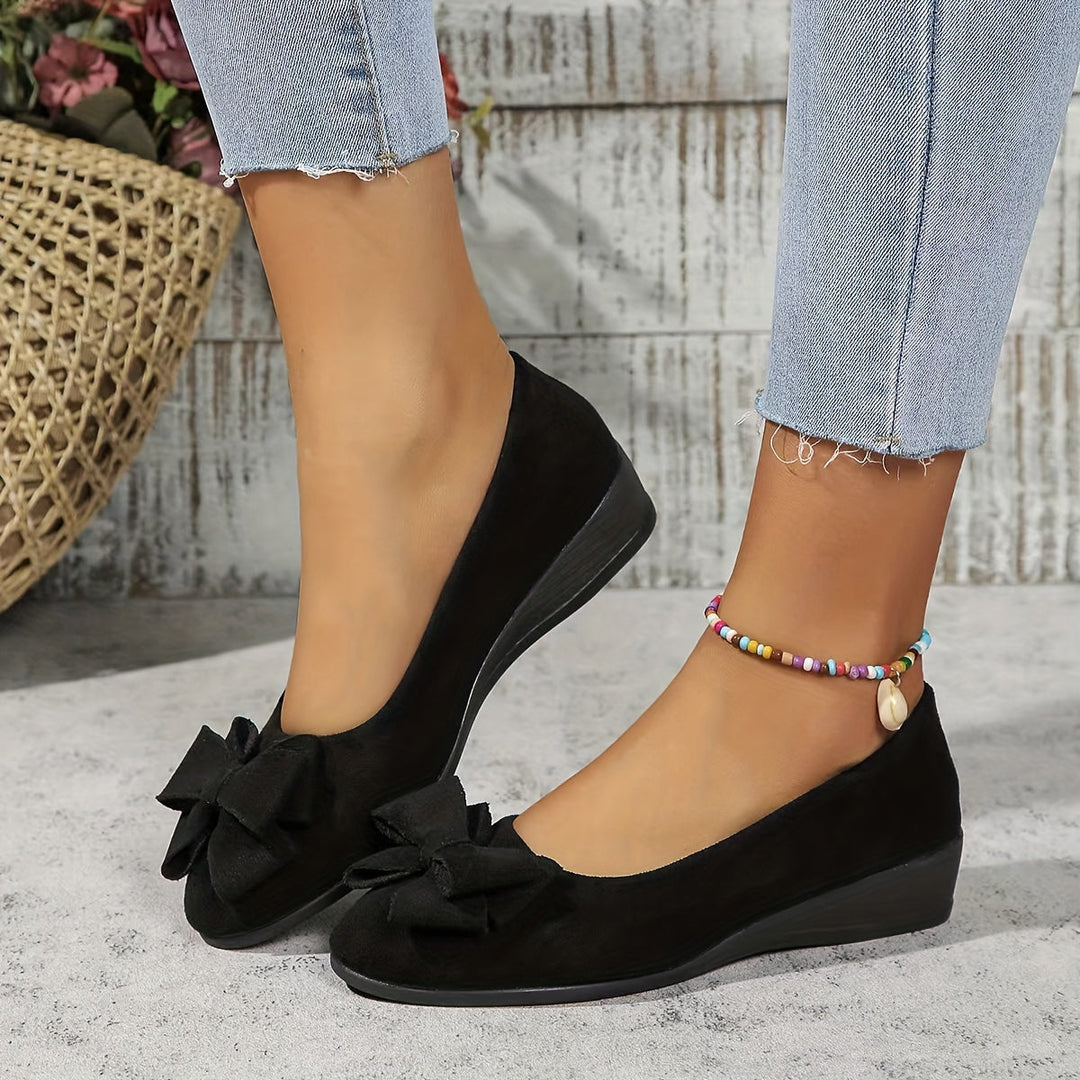 Elegant women's slip-on wedge flats, round toe with a pretty bow accent.