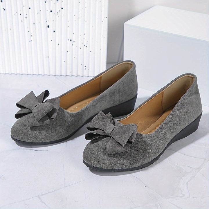 Women's soft textile slip-on wedge flats, round toe, elegant bow.