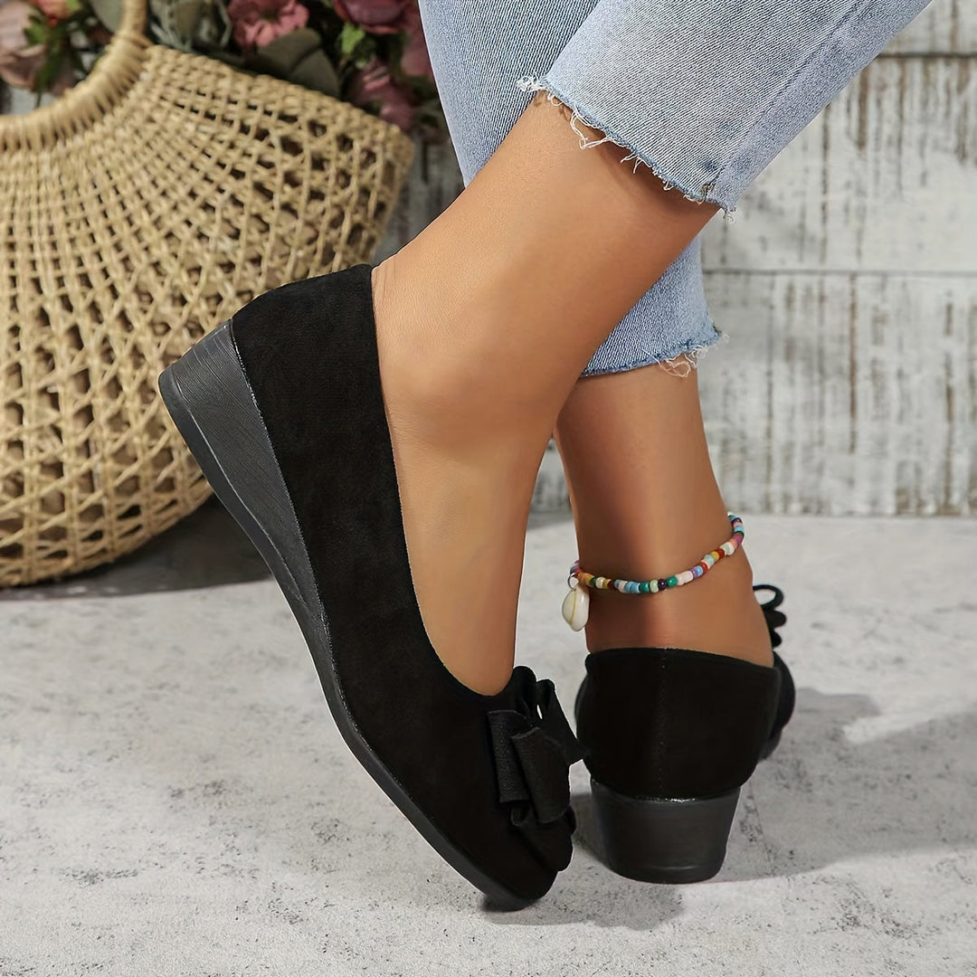 Round toe women's comfortable slip-on flats, elegant wedge and bow detail.