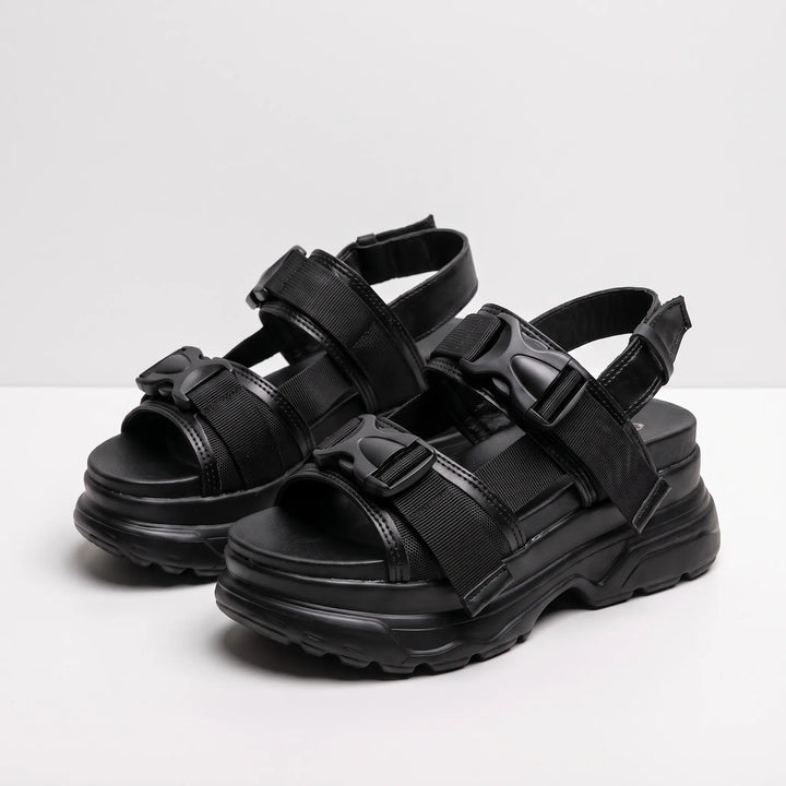 Stylish women's black chunky platform sandals with thick soles and secure buckle closures, great for street fashion.