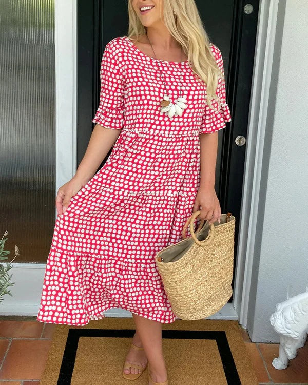 Women's black dotted midi dress with a relaxed fit and flowy tiered skirt, perfect for summer casual elegance.
