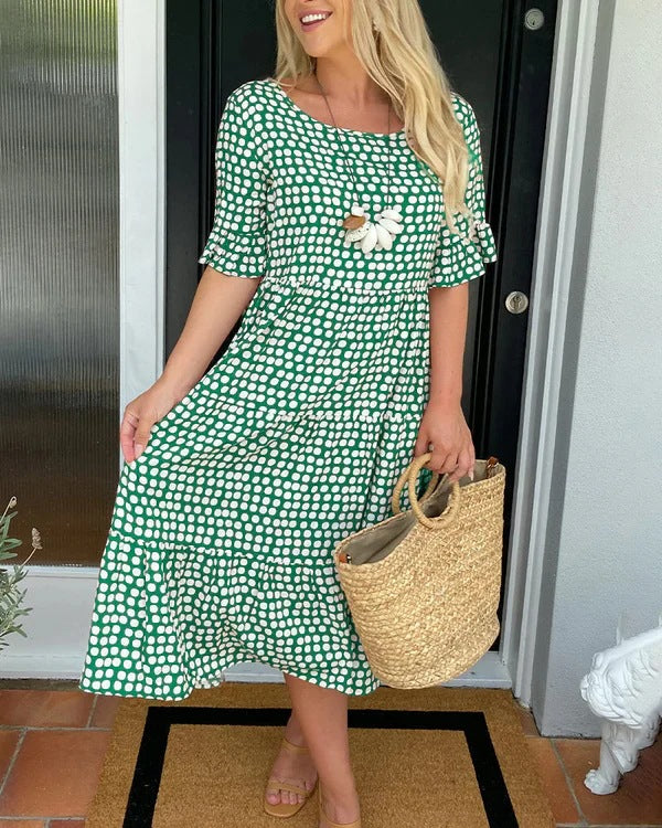 Versatile women's dotted midi dress, combining a relaxed fit and flowy tiered style for casual or elegant summer wear.