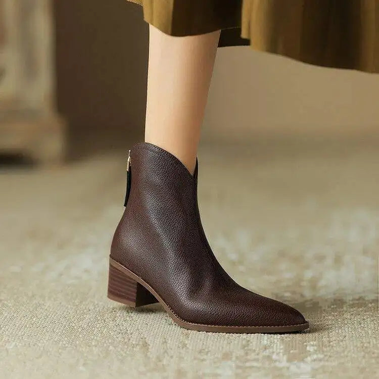 Women's black pointed toe slip-on ankle boots with a low heel, perfect for office wear.