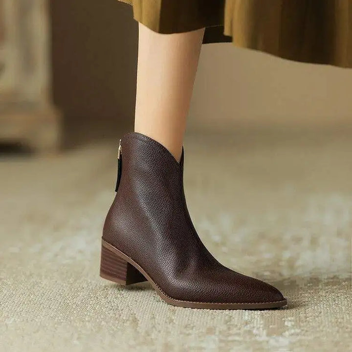 Women's black pointed toe slip-on ankle boots with a low heel, perfect for office wear.
