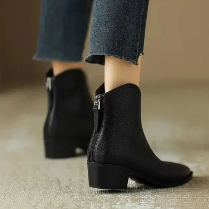 Sleek black pointed toe slip-on women's ankle boots, low heel, essential for office fashion.