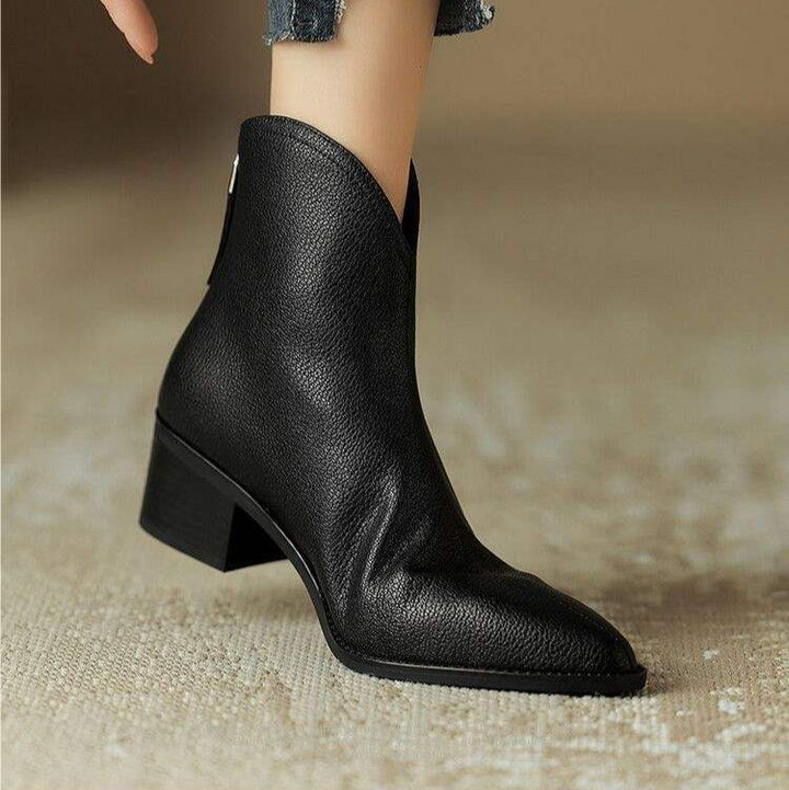 Side profile of elegant women's pointed toe slip-on ankle boots with a subtle low heel for office style.