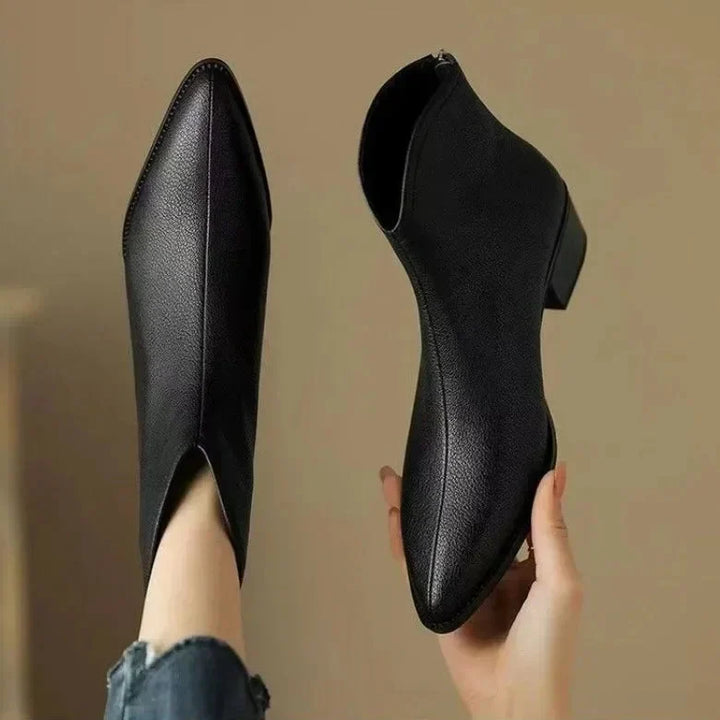Front view of chic women's pointed toe ankle boots, low heel, slip-on design, perfect for professional looks.