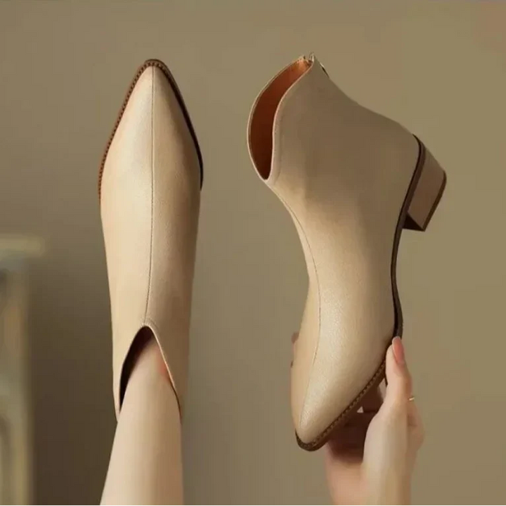 Close-up of elegant pointed toe and low heel on women's slip-on ankle boots, ideal for office.