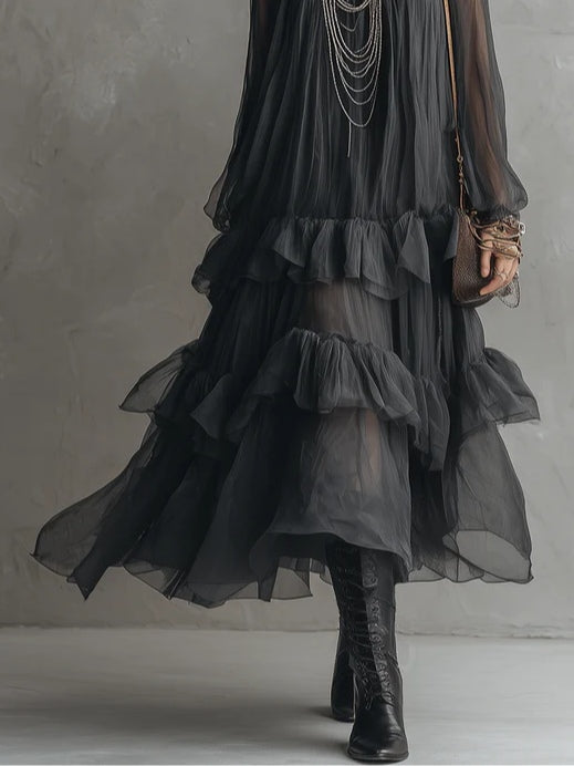 Stylish women's black sheer tiered maxi dress with a V-neck, ruffles, and flowy silhouette. Ideal for boho elegance.
