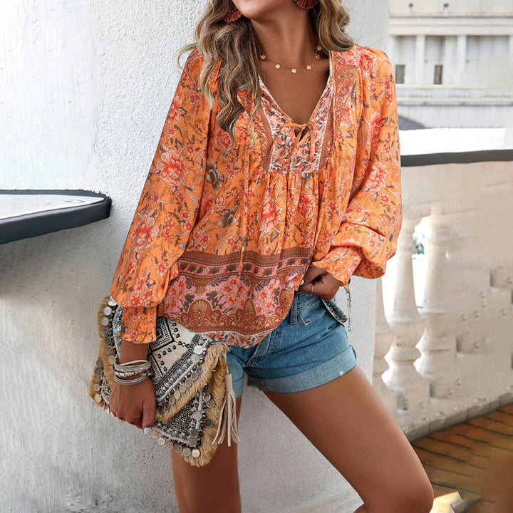 Bohemian women's blouse with bright floral print, loose fit, V-neck, and trendy puff sleeves for summer.
