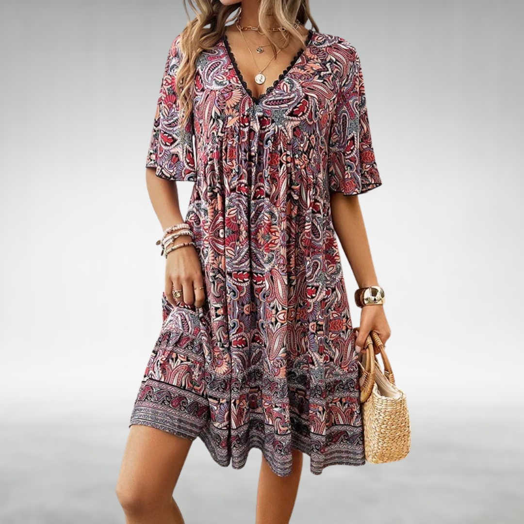 Woman wearing a vibrant boho paisley print short sleeve mini dress. Flowy design for casual summer comfort & vacation style.