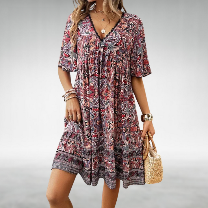 Woman wearing a vibrant boho paisley print short sleeve mini dress. Flowy design for casual summer comfort & vacation style.