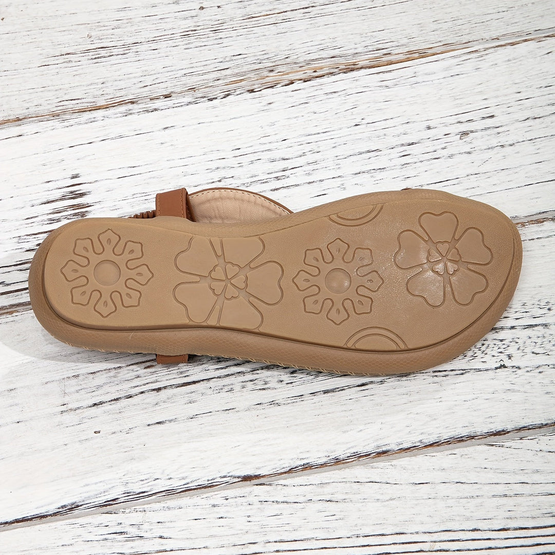 Close-up detail of the artisan beadwork and shimmering rhinestone embellishments on flat sandals.