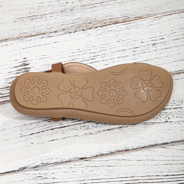Close-up detail of the artisan beadwork and shimmering rhinestone embellishments on flat sandals.
