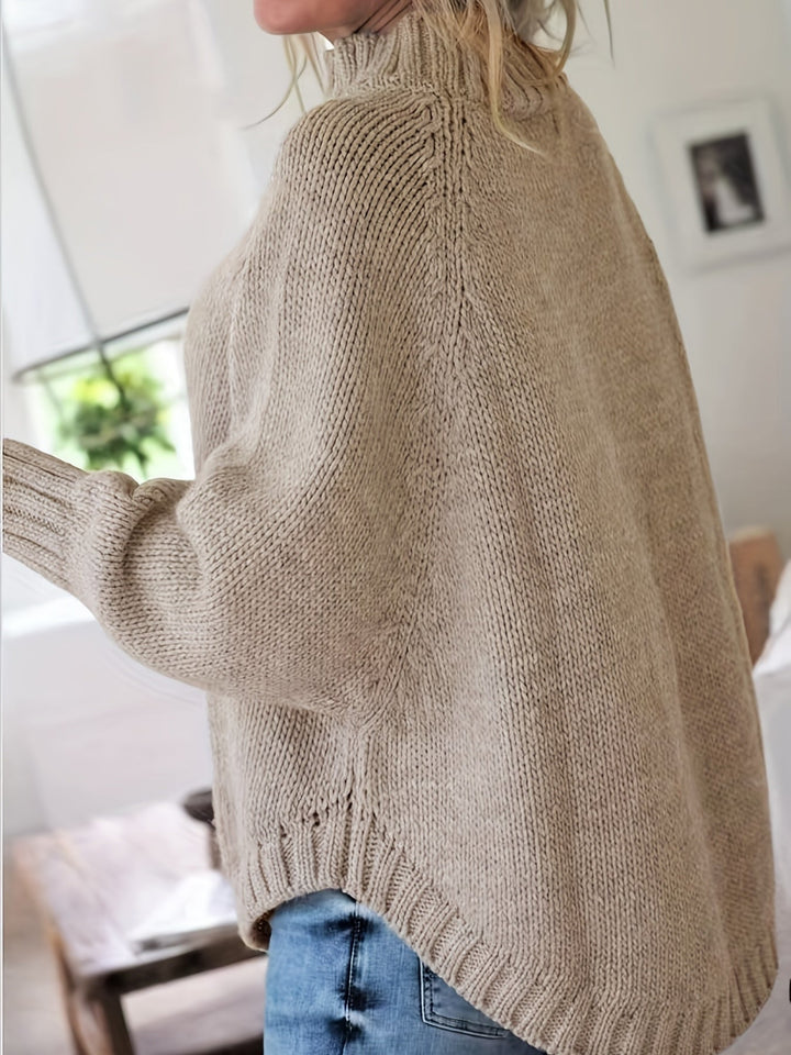 Warm women's cable knit high-neck sweater with a fashionable flared hem, essential fall winter wear.