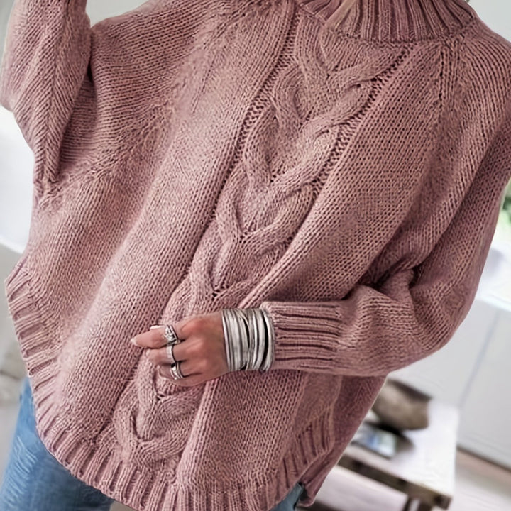 Classic women's cable knit high-neck sweater updated with a chic flared hem, perfect for fall fashion.