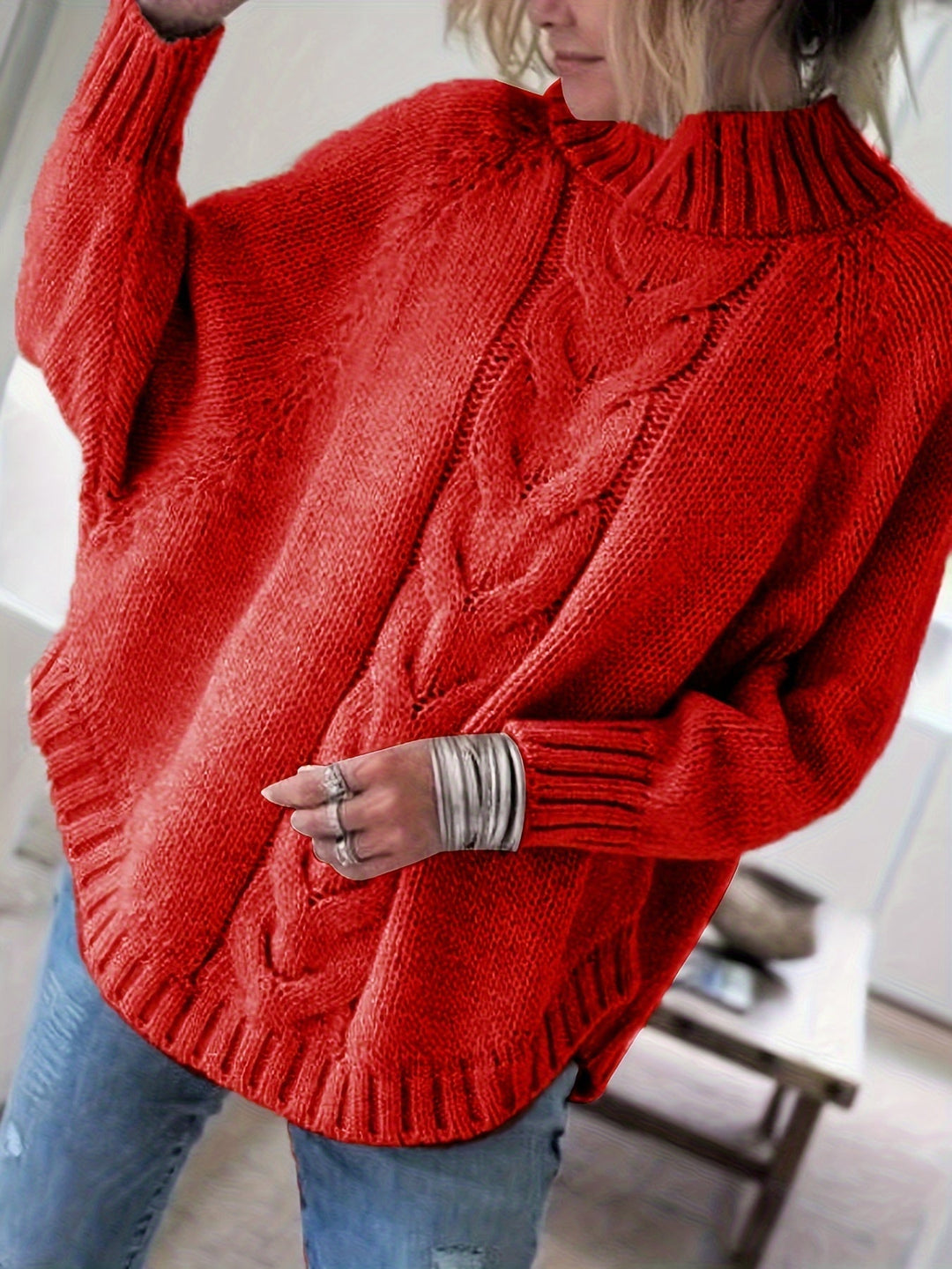 Cozy women's cable knit high-neck sweater with elegant flared hem, ideal for winter wear.