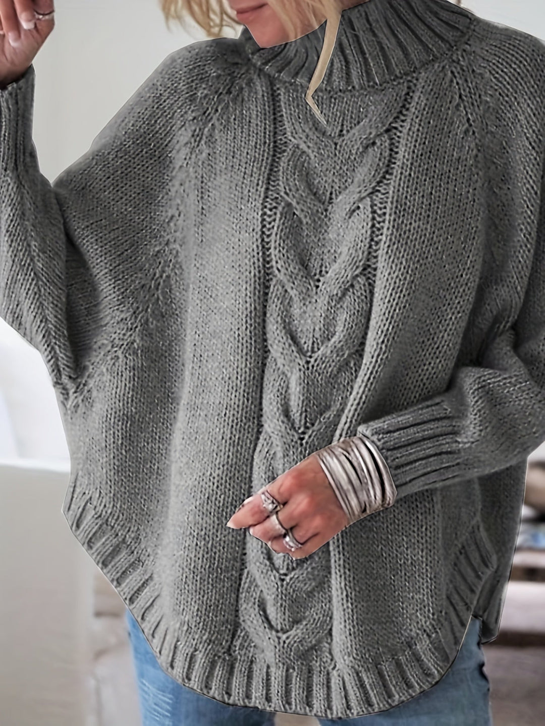 Oversized women's cable knit high-neck sweater with a vintage flared hem, fall fashion.