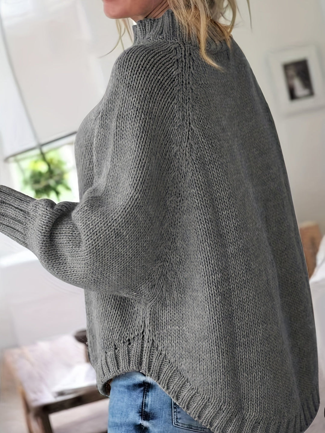 Detailed cable knit women's sweater with a high neck and flattering flared hem, great for fall.