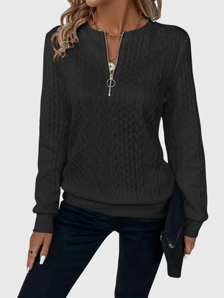Modern women's cable knit quarter-zip pullover, blending comfort and sophisticated style.