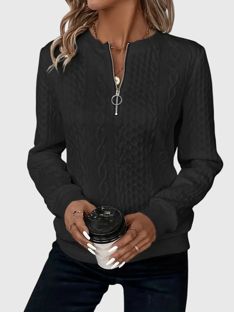 Fashionable women's cable knit quarter-zip pullover, featuring intricate textured design.