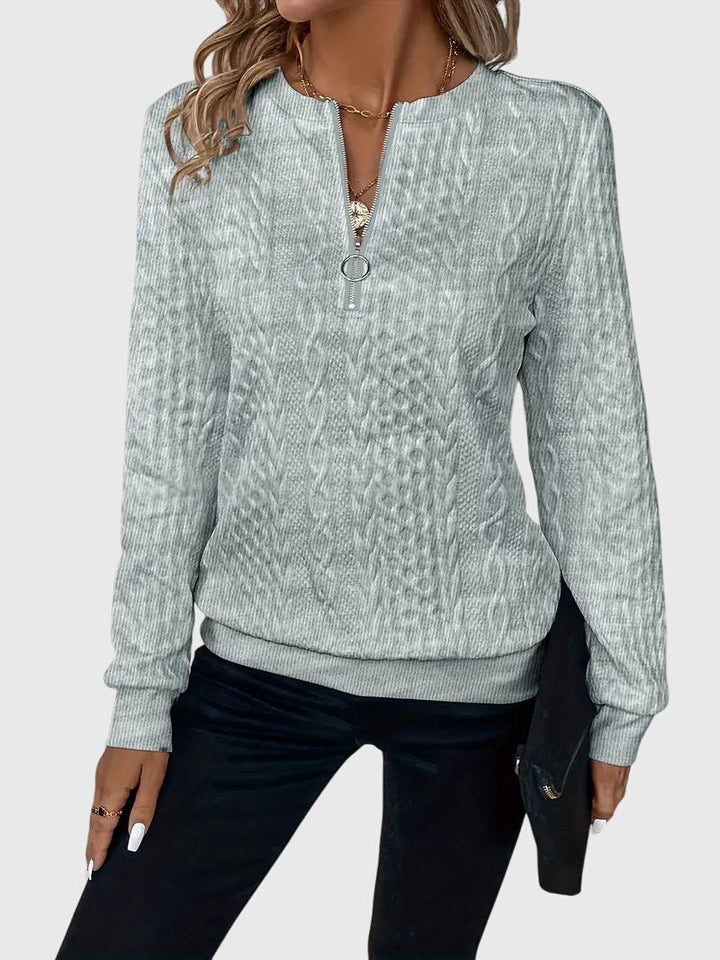 Warm women's cable knit quarter-zip sweater, an essential long sleeve for cold weather.