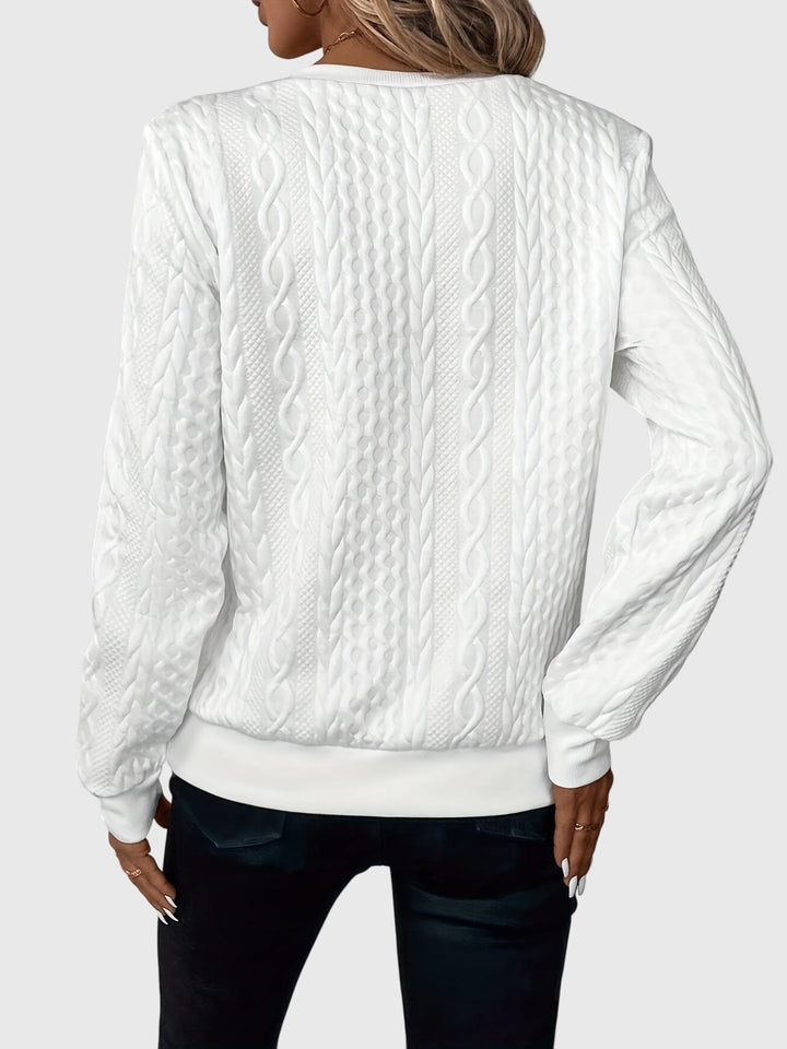 Stylish women's cable knit quarter-zip pullover, a textured long sleeve knitwear piece.
