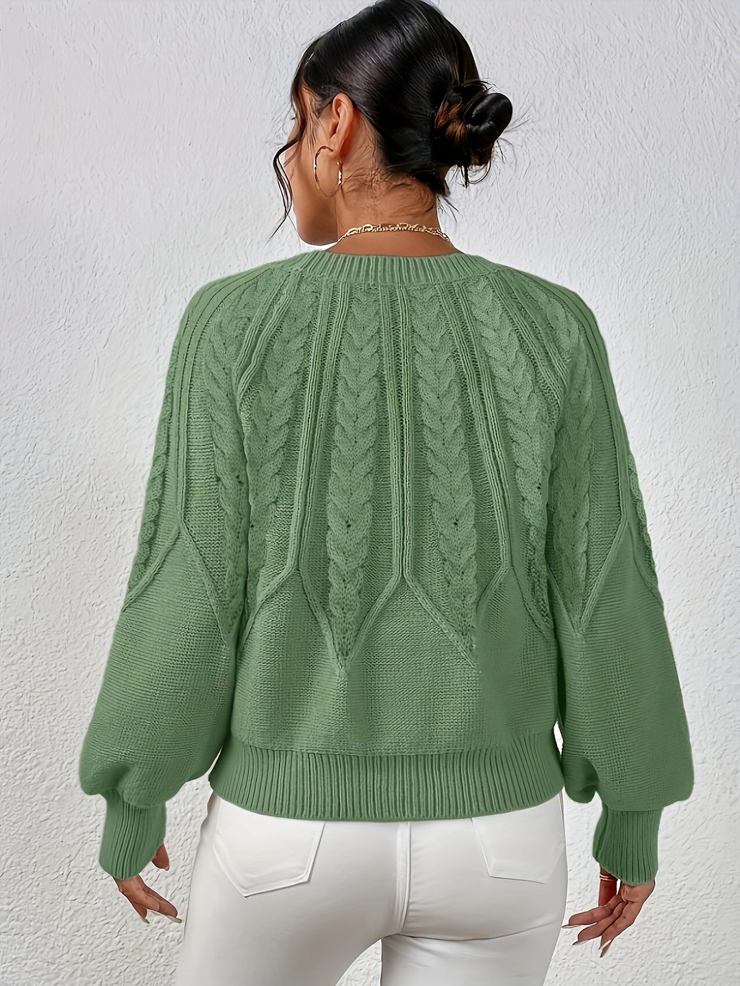 Women's cable knit sweater with relaxed fit and stylish lantern sleeves for winter.