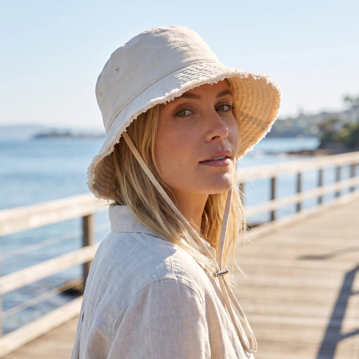 Women's casual bucket hat, frayed brim, adjustable chin strap, perfect for summer sun protection.