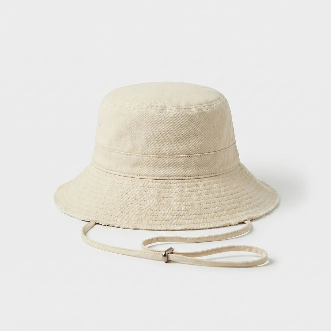 Foldable women's bucket hat with adjustable strap, ideal for travel, beach, and sun protection.