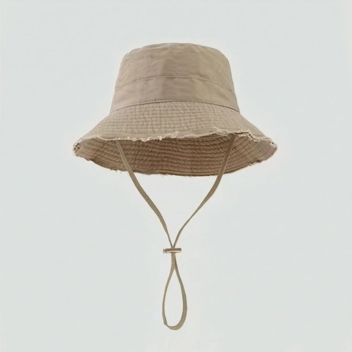 Casual women's bucket hat, adjustable chin strap, foldable for travel, stylish sun protection.