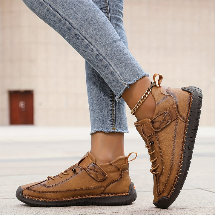Close-up of women's casual lace-up sneakers, highlighting the intricate stitched details and texture.