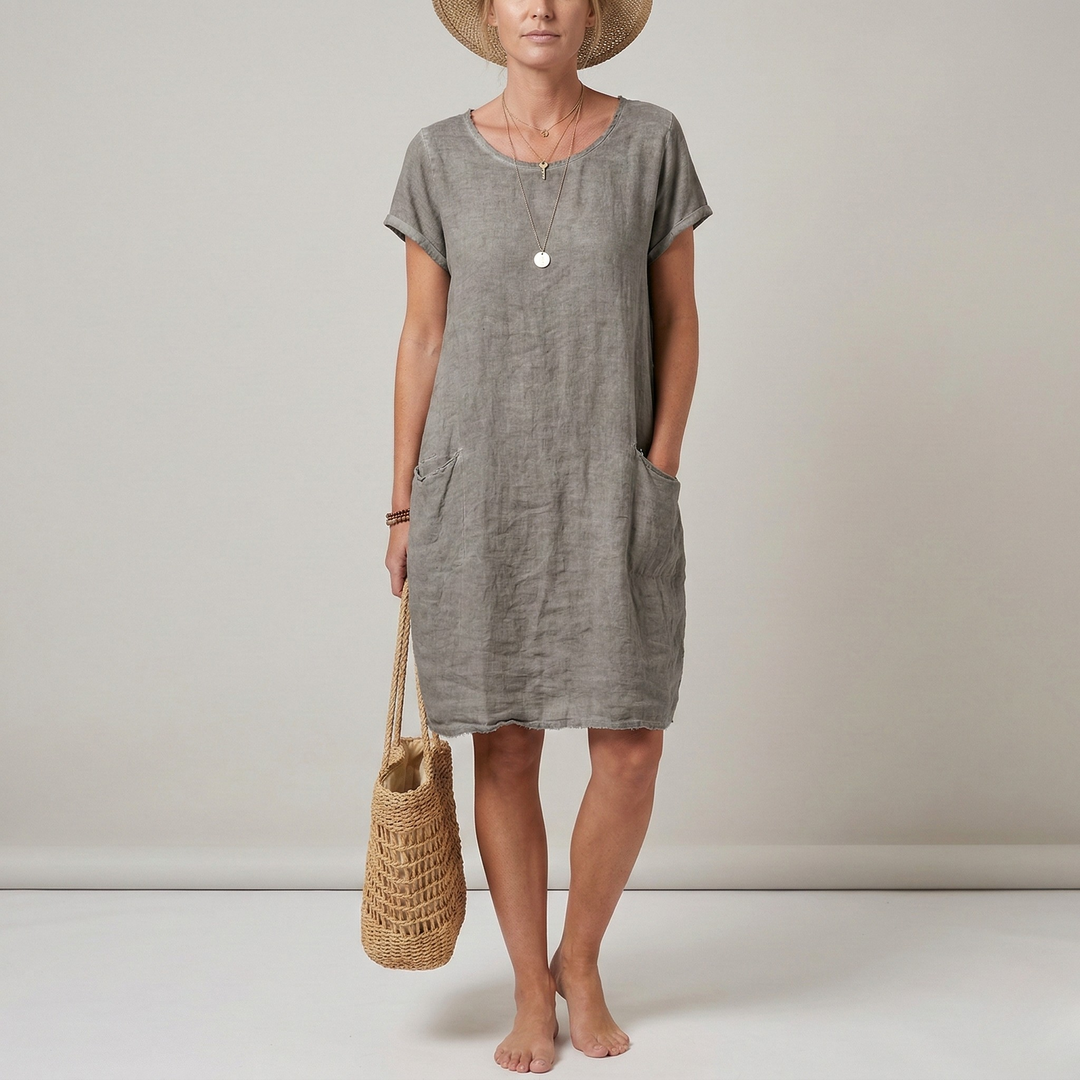 Woman wearing a loose-fit, short sleeve summer dress with pockets. Perfect casual style for a hot weather vacation.