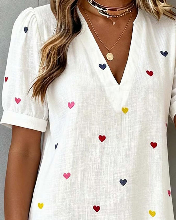 Feminine heart print V-neck mini dress with puff sleeves. Stylish casual summer vacation wear for women.