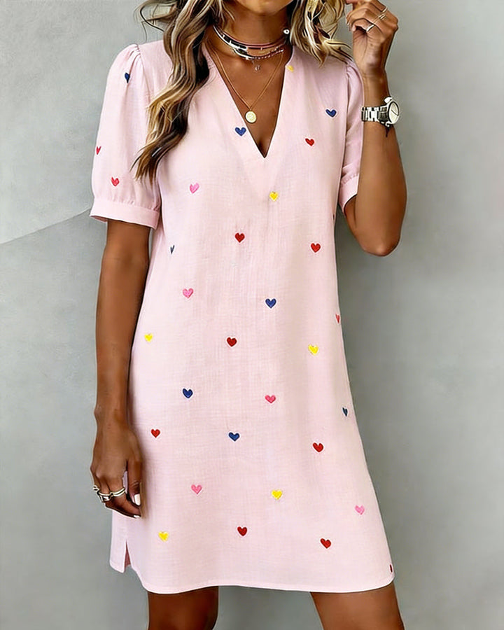 Relaxed fit women's V-neck dress featuring charming heart print & puff sleeves. Great for casual comfort.