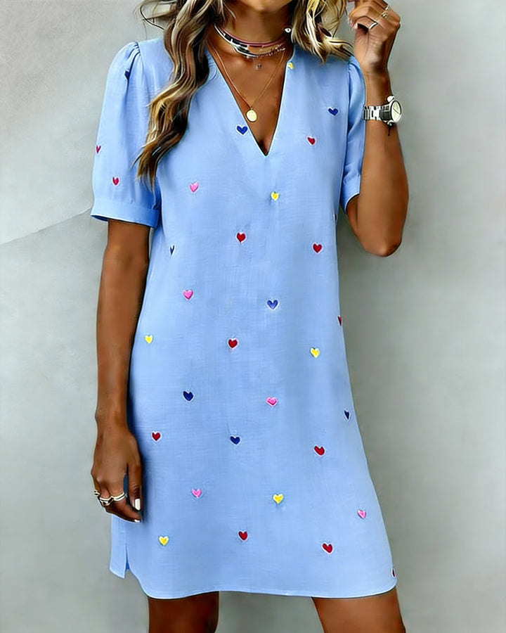 V-neck mini dress for women, featuring a vibrant heart print & playful puff sleeves. Casual & comfortable.
