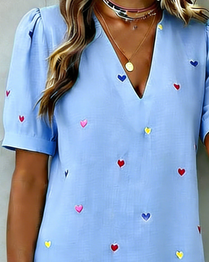 Women's heart print summer mini dress. Casual V-neck design, puff sleeves, relaxed fit for vacation style.
