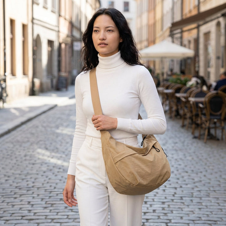 Stylish half-moon shoulder bag for women, featuring a unique braided strap. Versatile accessory.