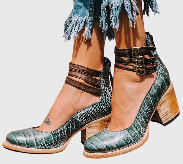 Statement women's black ankle boots with elegant cutouts, practical buckle, and a confident block heel.