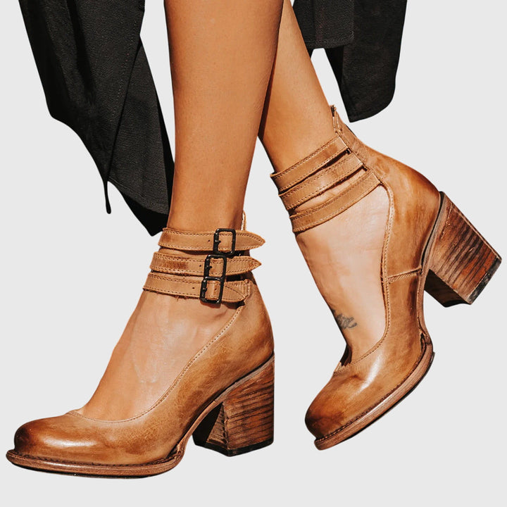 Elegant women's black ankle boots with trendy cutouts, buckle detail, and a supportive block heel for comfort.